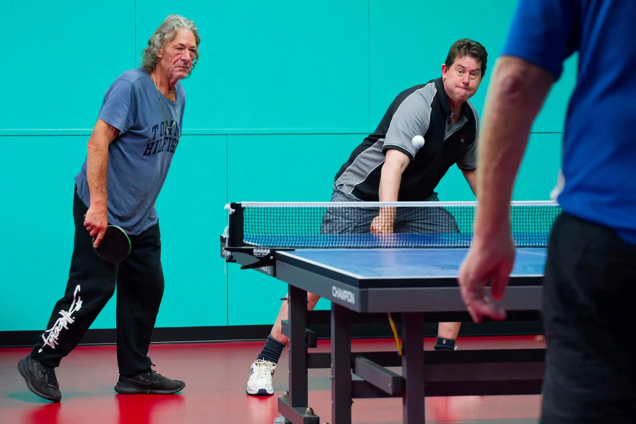 A doubles match at the clubrooms, on the red Taraflex floor